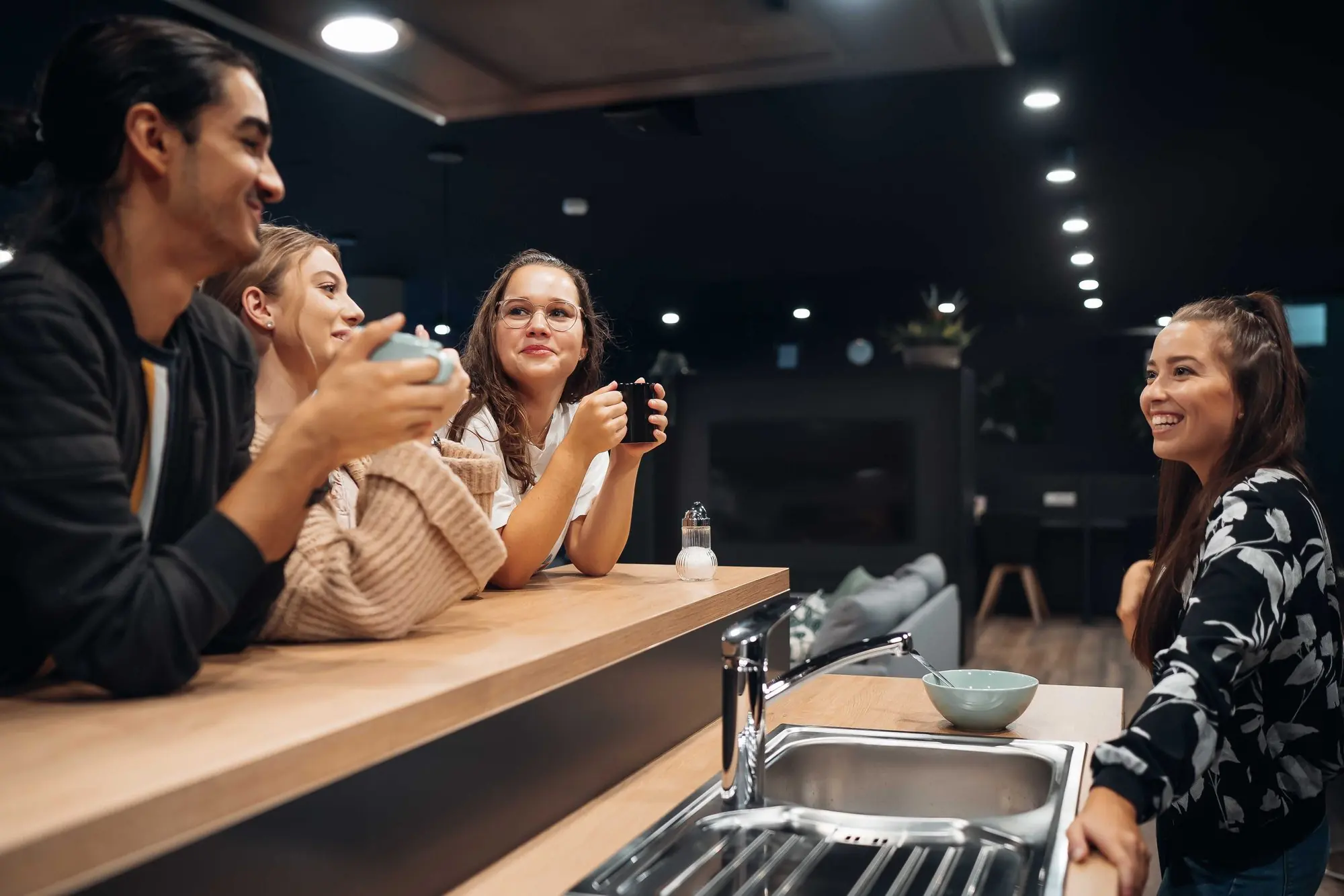 i Live residents sharing coffee and conversation in a communal kitchen